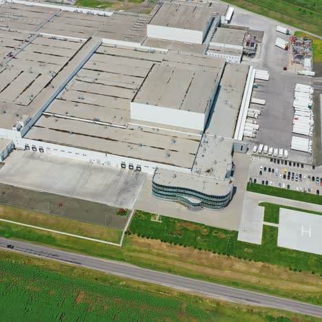 industrial plant on green field. modern manufacturing with car parking. large industrial territory with many buildings near the road. aerial view