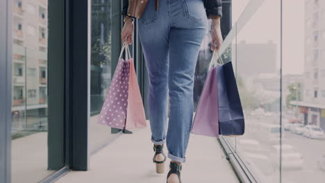 bolsas de compras, caminando y las piernas de la mujer en el centro comercial
