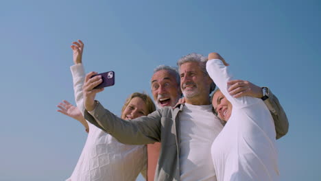 senior people taking selfie in background of blue sky