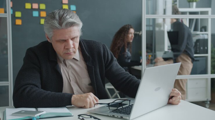 Forretningsmand, der arbejder på bærbar computer på moderne kontor