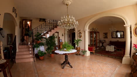 Woman-coming-down-the-stairs-of-a-spanish-style-house