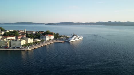 Drone-Levanta-Sobre-El-Adriático-Azul-Mientras-El-Crucero-Está-Atracado-En-El-Casco-Antiguo-De-Zadar-En-Croacia