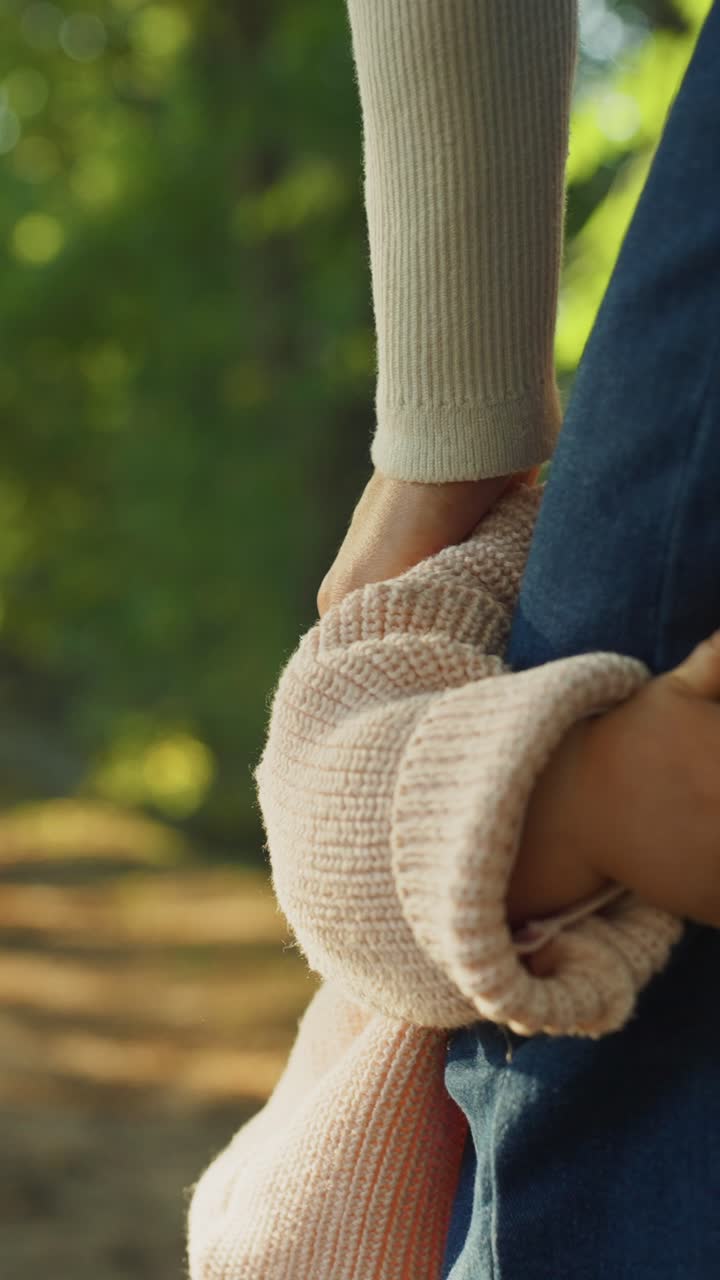 Happy Toddler Smiling and Holding Parent's Hand in Sunny Park