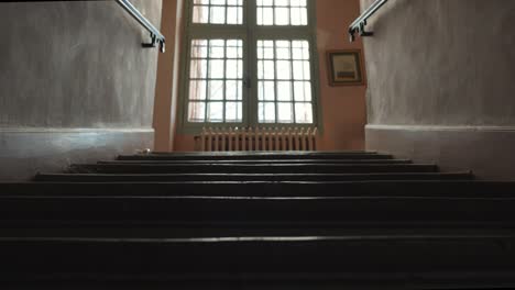 low tilting shot revealing a large bay window letting light into the stairwell