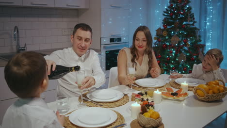 gran familia caucásica feliz de diferentes generaciones celebrando navidad en casa. la gente tiene una cena fiesta de navidad comiendo hablando y sonriendo. imágenes de alta calidad 4k