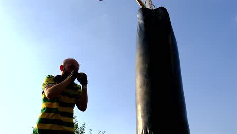 athlete-trains-with-a-punching-bag-attached-to-a-basketball-hoop-in-nature