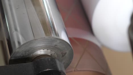 vista de cerca del rodillo de metal estirando bolsas de celofán de plástico
