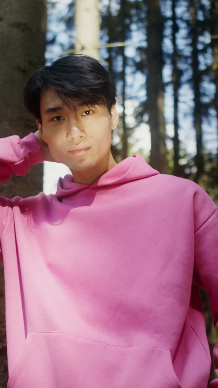 Man in pink hoodie in a forest