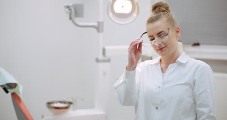 young positive female dentist smiling at dental clinic 2