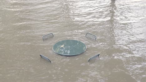 heavy flood from river submerging outdoor table and chairs - angle variation