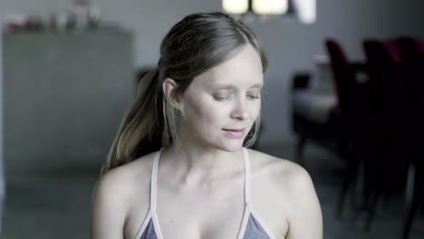 front view of pregnant woman sitting in lotus pose and drinking