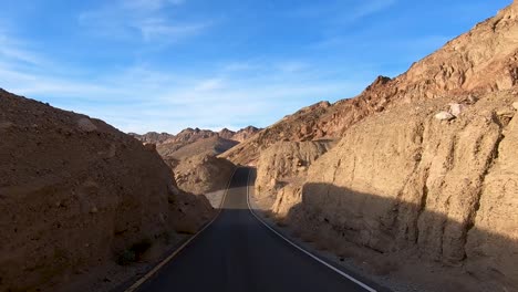 dip on paved road in death valley national park with stunning landscape