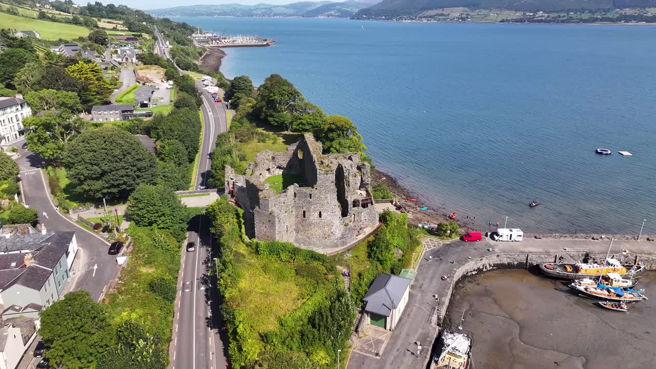 Aerial dynamic reveal of Carlingford Castle on Irish coastline. Architecture, heritage