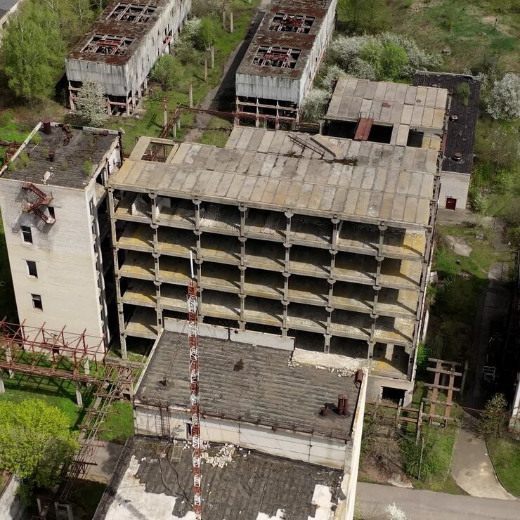 Edifícios industriais antigos. Antiga fábrica com edifícios em ruínas em zona abandonada na primavera. Câmera subindo