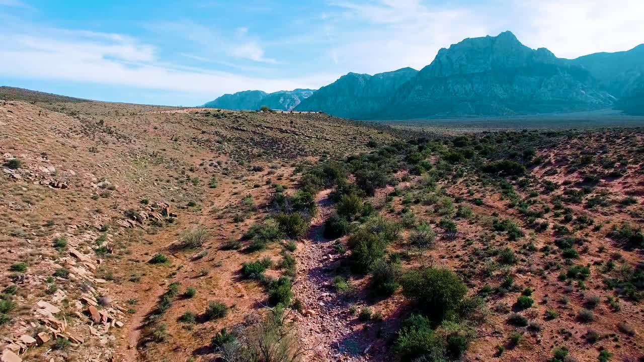 Flying through Red Rock Canyon towards mountain on a sunny summer day