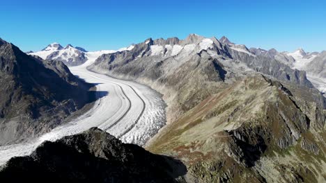 aerial flyover alongside the bettmerhorn next to the longest glacier in the alps - the aletsch glacier in valais, switzerland on a sunny summer afternoon