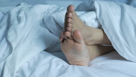 Woman-feet-on-the-white-bed-,