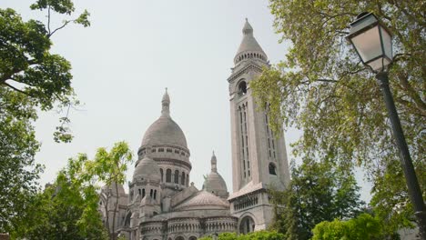 dome and bell tower of the famous sacre-coeur basilica as seen from montmartre in paris, france on a sunny day