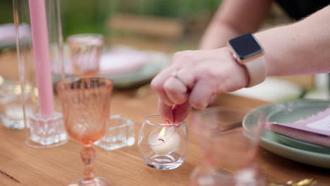 event staff setting up table by lighting decorative candles, close up slow motion 4k