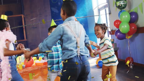 children wearing party hats dancing in circle with confetti animation