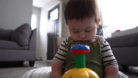 hispanic latino baby with toy in living room