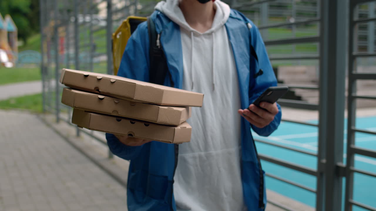 Pizza delivery man with pizza boxes and phone
