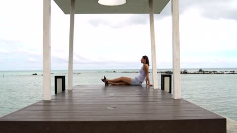 woman resting on the quay near the sea