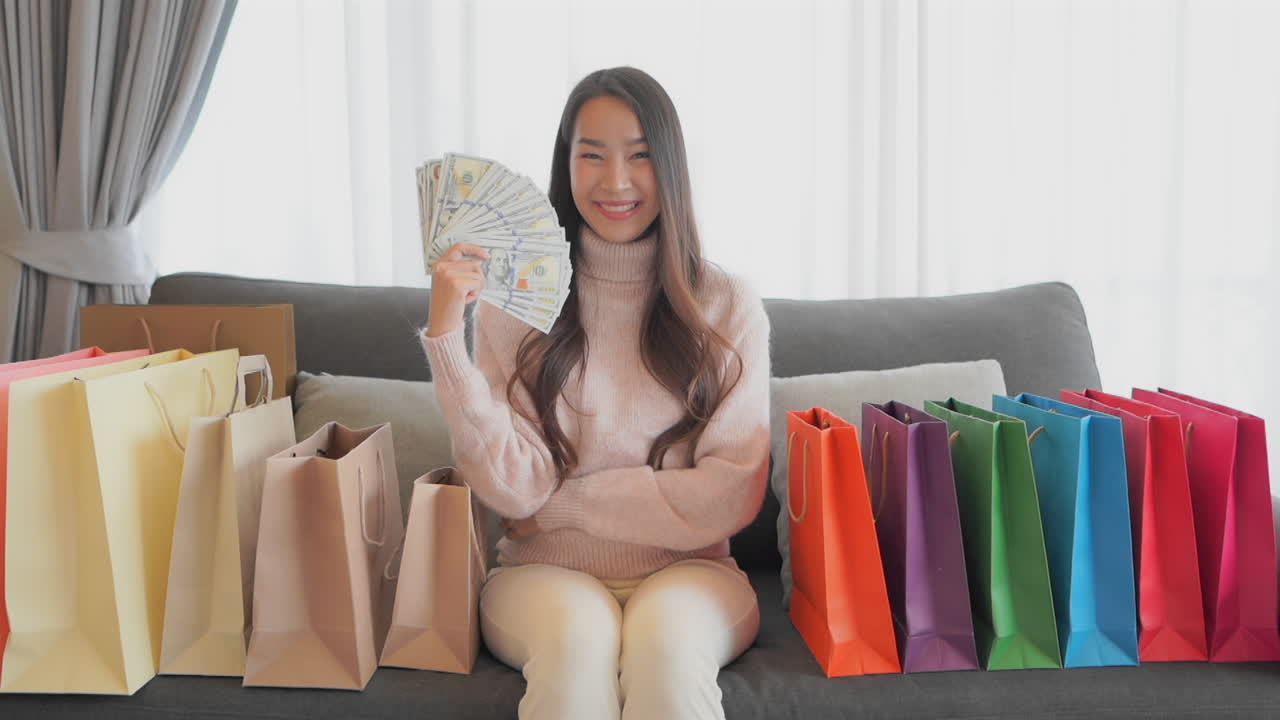 Image of young rich woman holding cash money, joyful with lots of shopping bags