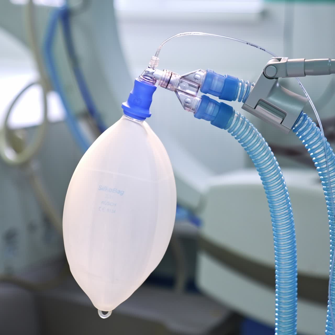 Moving ambu bag with connected tubes hanging in the surgery room. Close up. Blurred background
