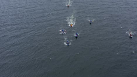 Frontal-aerial-view-of-currach-racing-boats-in-galway-paddling-towards-open-ocean