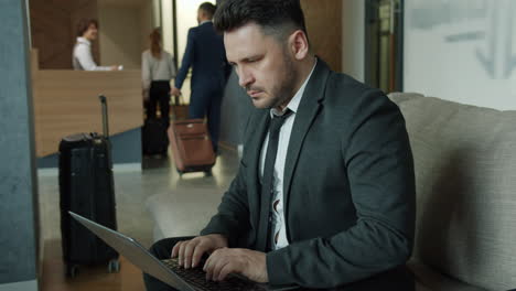 businessman working on laptop in hotel lobby