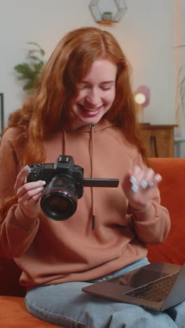 mujer feliz fotógrafo con portátil mientras sostiene cámara digital mirando la pantalla eligiendo fotos