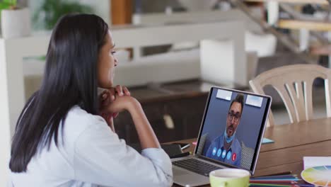 Caucasian-woman-using-laptop-on-video-call-with-male-colleague-working-from-home