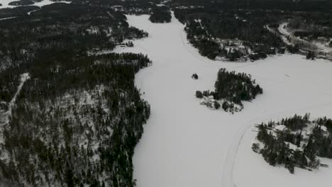 Aerial-dolly-forward-of-a-frozen-Canadian-lake-in-Canada's-northern-boreal-forest