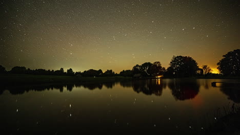 Lapso-De-Tiempo-De-Estrellas-En-El-Cielo-Estrellado-Que-Se-Refleja-Sobre-La-Superficie-Del-Agua-Del-Lago-Al-Amanecer