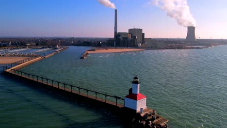 michigan city lighthouse and pier on lake with electrical substation and washington park beach in background, indiana