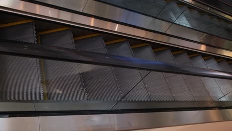 an almost empty escalator inside a high-end mall in the heart of the city of bangkok, thailand