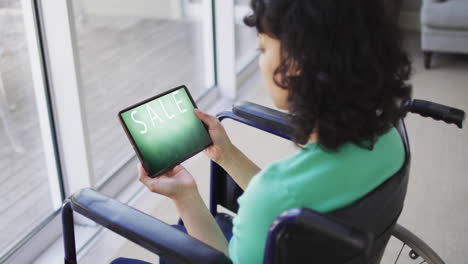 Biracial-woman-in-wheelchair-using-tablet,-online-shopping-during-sale,-slow-motion