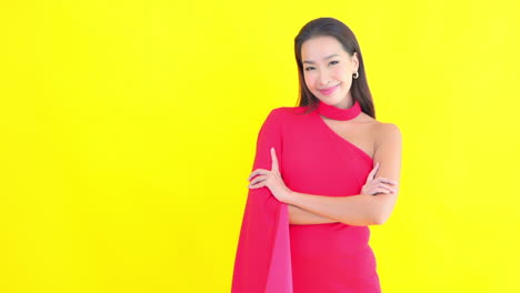 팔짱을 낀 채 팔짱을 끼고 서 있는 팔색깔의 배경에 대해 웃고 있는 젊은 여성