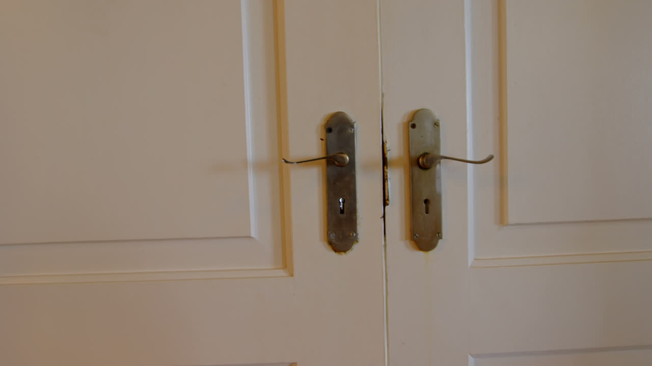 vista frontal de una joven familia caucásica entra por la puerta principal en una casa cómoda 4k