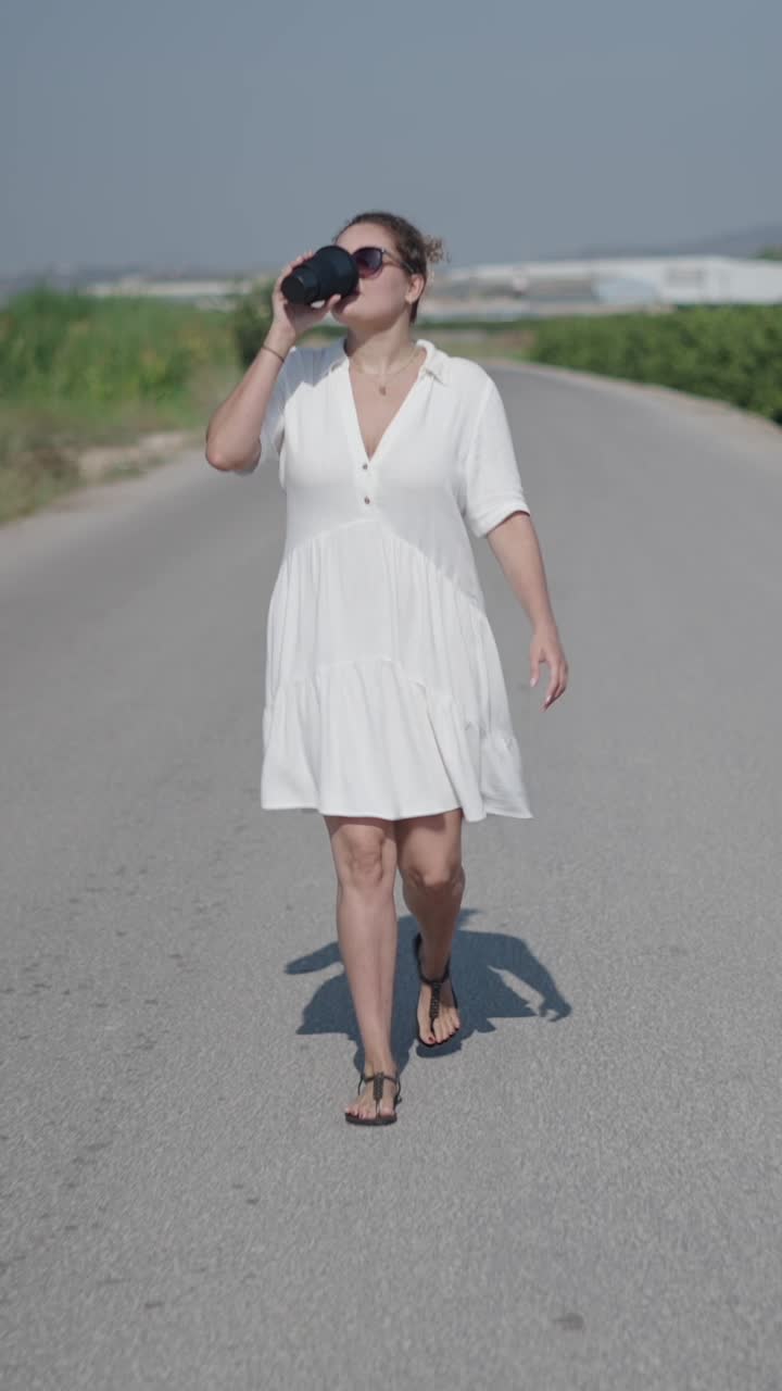 Donna che beve caffè per strada