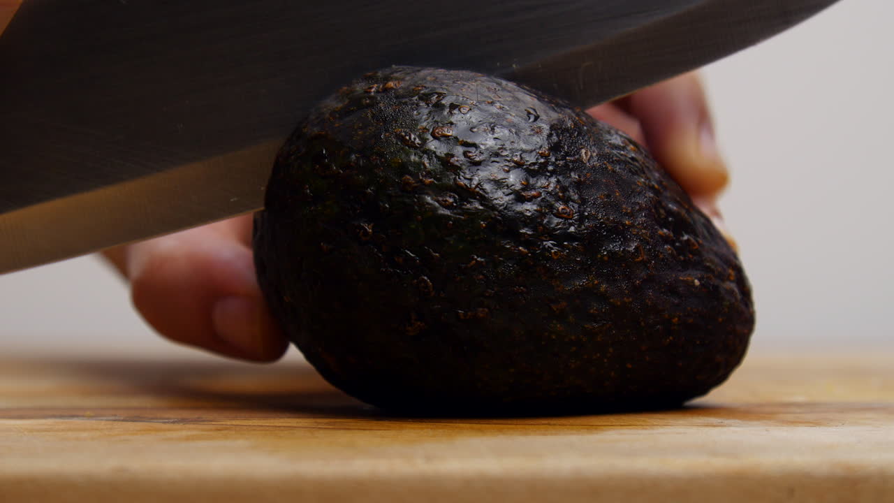 persona cortando un aguacate