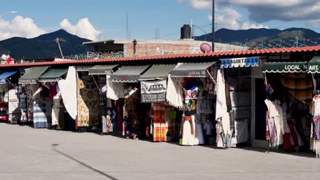 Slow motion landscape of clothing products and hand-made goods local business in shopfront at Mitla markets San Pablo Oaxaca Mexico business travel holidays community