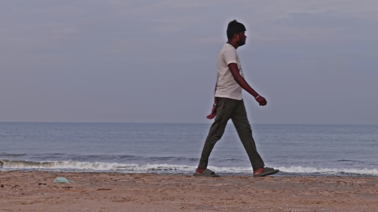 Indian person walking in marina beach or sand Beach at Triplicane, Chennai, Tamil Nadu, india. sun set time, pan shot, 4k.