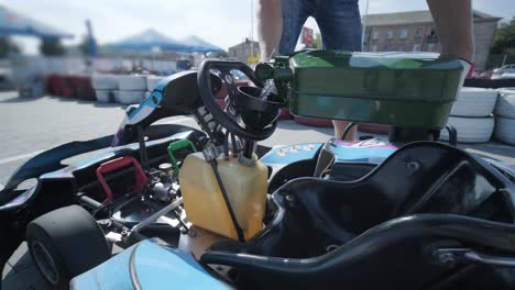 el mecánico del servicio de carreras de karts vierte combustible en el tanque.