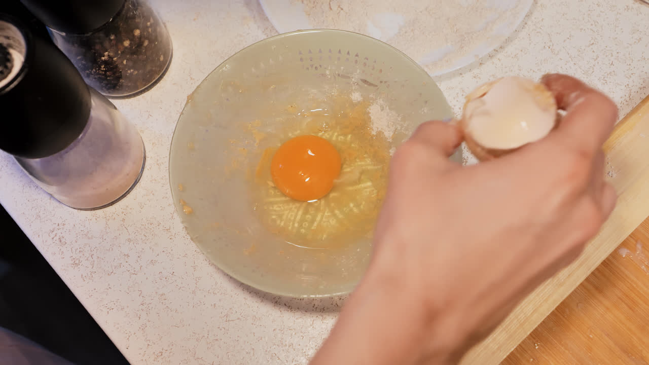 Close-up of young woman beating eggs as a first step in home recipe preparation