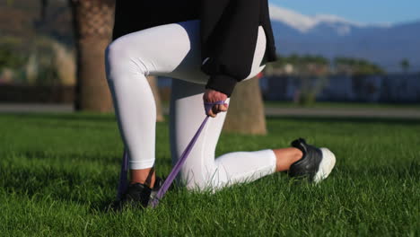 woman exercising with resistance band in a park