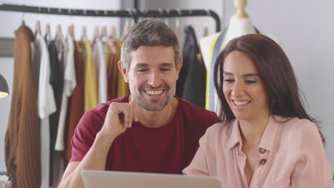 Männliche-Und-Weibliche-Modedesigner-Im-Studio-Führen-Videoanrufe-Am-Schreibtisch-Auf-Dem-Laptop-Durch