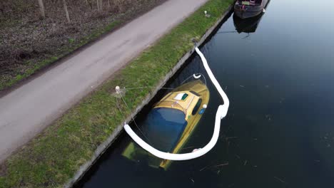 aerial shot of yellow motorboat anchored on dock sunken underwater in harbor