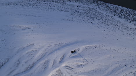 Aerial-rising-shot-showing-people-packing-away-gear-in-a-mountain-valley-in-Iceland